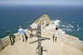 Tourists looking at panoramic view of Cape Point, Cape of Good Hope, outside Cape Town, South Africa shows confluence of Indian