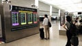 Tourists looking at screens in airport