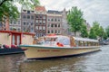 Tourists making sightseeing trip by launch ship in Amsterdam canals