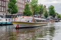 Tourists making sightseeing trip by launch ship in Amsterdam canals