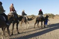 Tourists mount camels for a ride in the Sahara