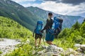 Tourists in mountain trek. Two friends in mountains. Hiking on hills and mounts. Hikers walks on rocky way.