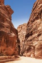 Tourists in narrow passage of rocks of Petra canyon in Jordan. Petra has been a UNESCO World Heritage Site since 1985. Royalty Free Stock Photo