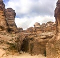 Tourists in narrow passage of rocks of Petra canyon in Jordan