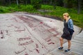 Tourists near rock carvings from Bronze Age, which are about 3000 years old. Tanum, Sweden