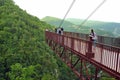 Tourists on observation deck look down into deep gorge.