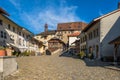 Tourists on the old medieval road in Gruyeres, Switzerland, in autumn light.