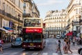 Tourists in an open sightseeing bus on a tour at the street of downtown of Paris