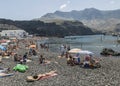 Tourists on pebbly beach at Puerto de las Nieves, on Gran Canaria.