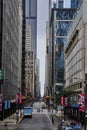 Tourists and pedestrians on Chicago street corridor between skyscraper buildings on gloomy day