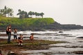 Tourists photograph the temple Tanah Lot