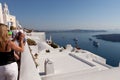 Tourists photograph the view of the caldera, Santorini island