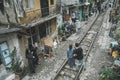 tourists are photographed on the railway waiting for the train among the old houses of the poor quarter. Hanoi. Vietnam