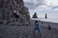 Tourists photographing at the Black Beach, Iceland