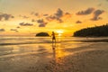 Tourists playing frisbee on the beach in golden sunset