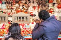 Tourists playing shooting game to win plush toys on the wall at Christmas funfair winter wonderland