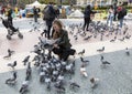 Tourists in Plaza Catalunya in Barcelona feeding the pigeons and taking pictures of them