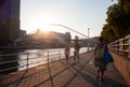 Tourists on the promenade next to the Nervion River near the Zubizuri Bridge at sunset, Bilbao Euskadi, Spain Royalty Free Stock Photo