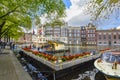 Tourists purchase tickets at a booth for boat tours on a canal in the historic center of Amsterdam, Netherlands