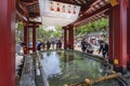 Tourists purifying themself with water in ladles at an ablution basin called temizuya or chÃÂzuya in Dazaifu shrine Royalty Free Stock Photo