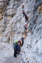 Tourists queue on crowded via ferrata Giovanni Lipella route, in Dolomites, Italy, a popular tourist attraction during Summer