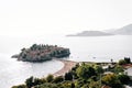 Tourists relax on the beach of the isthmus near the island of Sveti Stefan. Montenegro