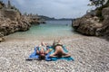 Tourists relax on the rock beach in the Mediterranean seaside town of Kas in Turkey.