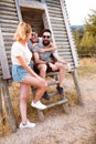 Tourists relaxing. Group of three friends sitting on wooden camp stairs enjoying and laughing in the countryside. Camp adventure