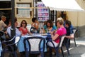 Tourists relaxing at a shaded pavement cafe, Ronda, Spain.