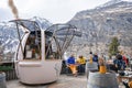 Tourists resting while worker working in open stall at resort during winter