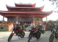 The tourists ride big motor bikes with the background of a pagoda worship place in Blora,Central Java.