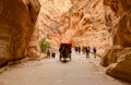 Tourists ride in a carriage and go through the gorge in Petra, J