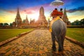 Tourists Ride an Elephant at Wat Chaiwatthanaram temple in Ayuthaya, Thailand