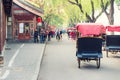 Tourists riding Beijing traditional rickshaw in old China Hutongs in Beijing, China. Royalty Free Stock Photo