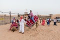 Tourists Riding Camel with Tamer in The Desert of Dubai