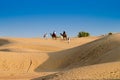 Tourists riding camels,Camelus dromedarius, at sand dunes of Thar desert. Camel riding is a favourite activity amongst all Royalty Free Stock Photo