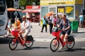 Tourists riding electric bike sharing bicycles, JUMP by UBER on street in Berlin