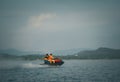 Tourists riding jet skis High-speed in sea or river with water spray People ride water scooters .