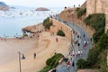 Tossa de Mar, Spain, August 2018. Tourists on the road near the walls of the old fortress, the sea and the beach in the early even