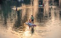 Tourists rowing on subboards and kayaks touring Khlong Chao in the evening on Koh Kood, Trat Province, Thailand