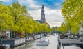 Tourists sailing in a canal boat on the Prinsengracht passing the Westertoren