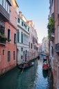 Tourists are sailing in gondolas along the canal in Venice and sightseeing