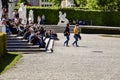 Tourists schoolchildren and students are sitting on the steps near the Belvedere Palace in Vienna. Vacations, holidays, weekends