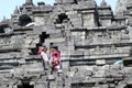 Tourists seen through a gap in the stonework at the Buddhist temple of Borobudur, near