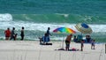 Tourists with shade umbrellas on the beach