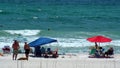 Tourists with shade umbrellas on the beach