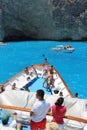 Tourists on a ship`s nose cruising azure sea