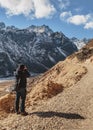 Tourists shoot black mountain with snow on the top and yellow stone ground at Thangu and Chopta valley in winter in Lachen.