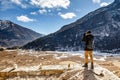 Tourists shoot black mountain with snow on the top and yellow stone ground at Thangu and Chopta valley in winter in Lachen.