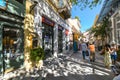 Tourists shop on one of the many narrow pedestrian streets of shops and cafes in the historic Plaka district of Athens, Greece